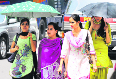 Girls protect themselves from the blazing sun in Chandigarh on Monday. 