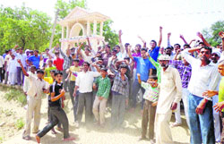 Residents of Farain Kalan village (Jind) protest outside the main gate of the school on Monday. Tribune photo