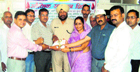Star blood donor Ashok Verma ( wearing a white cap), and others honour blood donors at LNJP Hospital in Kurukshetra recently.
