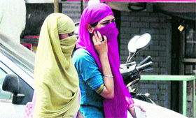 Girls cover their faces with duppatas to save themselves from scorching heat in Gurgaon.