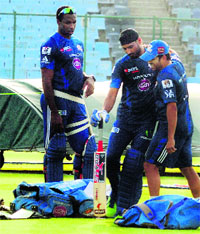 Harbhajan Singh and Sachin Tendulkar horse around as Kieron Pollard looks on during a training session in New Delhi on Sunday. 