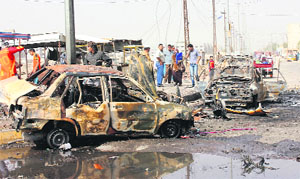 Residents gather at the site of a bomb blast in Basra, near Baghdad, on Monday.