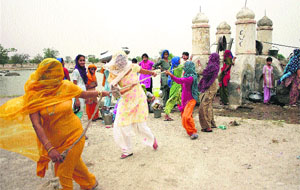 Women pull the pulley to draw drinking water from a well at Kila Zafargarh village of Jind district on Tuesday. 