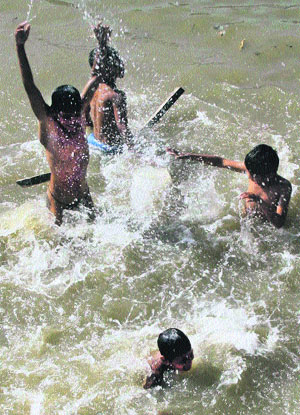 With the mercury rising to 45C, children try to beat the heat in a pond at Gurgaon on Tuesday.