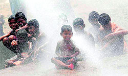 Slum children take a bath to get respite from scorching heat on the outskirts of Bhubaneswar on Tuesday