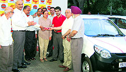 Officials of Indian Oil Corporation Limited hand over the keys of an Alto car to the winner in Chandigarh