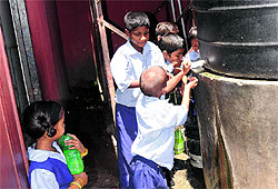 Children drink water directly from the storage tank at Government Primary School in Hallo Majra