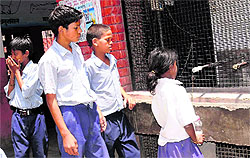 Children stare at non-functional water coolers at Government High School, Colony No. 4
