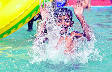 A boy takes a dip in an amusement water park at Dehradun on Wednesday to beat the heat