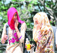 Girls cover their faces on a hot day in Shimla on Wednesday. 