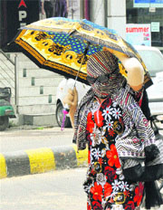 A woman covers herself to get respite from the scorching heat during a hot day in Karnal on Wednesday. 