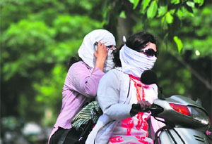 Girls ride a scooter on a hot afternoon in Ludhiana on Wednesday.