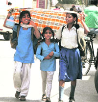  Kids protect themselves from searing heat while returning from their school in Bathinda on a hot Thursday afternoon.