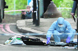 A police forensics officer investigates a crime scene where one man was killed in Woolwich, south-east London. Photos: Reuters