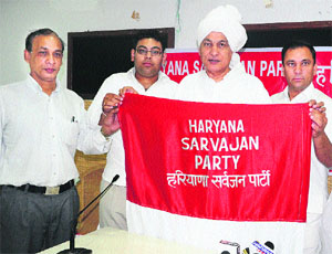 Roshan Lal Arya (in turban), president of the Haryana Sarvajan Party, along with others unveil the flag of the party at the Press Club in Sector 27, Chandigarh. 