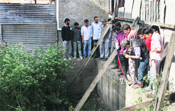 People look at a spot where the LeT militant was killed in an encounter with security forces in the old Srinagar city. Tribune photo