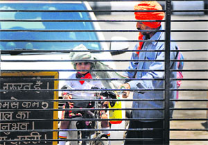 A man ties a turban on his child’s head to protect him from the scorching heat in Ludhiana.