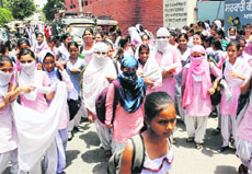 Schoolchildren going home amid scorching heat in Amritsar on Friday.