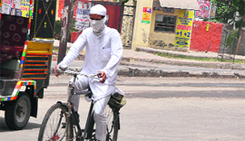 A cyclist makes his way through the heatwave with his face covered near DAV College in Bathinda on Friday.