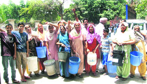 Facing acute shortage of water in the ongoing scorching heat, residents of the Santokhpura locality stage a dharna outside the Municipal Corporation office in Jalandhar on Friday. 