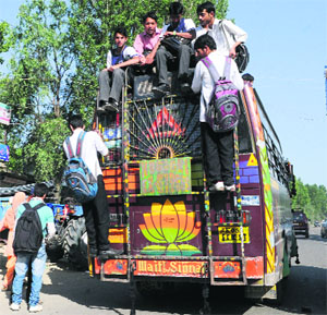 Schoolchildren atop an overcrowded bus at Pattan in north Kashmirs Baramullah district on Friday.