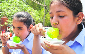 Schoolgirls enjoy ice candies on a hot afternoon in Ludhiana on Friday. 