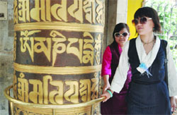 Buddhist girls rotate prayer wheels while offering prayer at a temple on Buddha Purnima, on the occasion of 2557th birth anniversary of Gautama Buddha, in New Delhi on Saturday. 