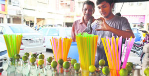 A roadside vendor prepares a lemon drink. 