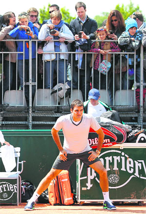 Former world No. 1 Roger Federer stretches before practice on Saturday. The French Open begins today.