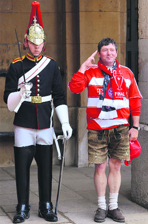A Bayern Munich supporter poses next to a member of the Queens Life Guard on duty outside of Horse Guards in central London on Saturday.
