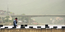 A man walks through a dust storm on Tawi Bridge