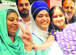 Navneet Kaur Sohanpal, who topped Mohali district with 95.8 per cent in the commerce stream of Class XII, with her family members on Monday
