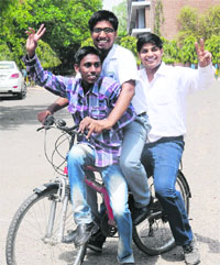 Ravi Kumar, whose mother does a cleaning job in a bank; Vikas Jain (centre), whose father is a vendor; and Rajat Kumar, whose father makes sweets boxes, in a jubilant mood after scoring well in the Class XII exams.