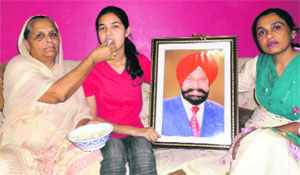 Gurleen Kaur, who secured 96 per cent in the medical stream, with her family on Monday. 