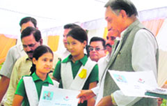 Uttarakhand Chief Minister Vijay Bahuguna distributes fixed deposit certificates to girl students during his visit to Tehri on Monday.