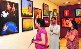 Visitors have a look at paintings displayed at an exhibition organised by NIFA at Epicentre in Gurgaon. 