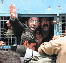 Police takes away protesting employees in custody in Srinagar on Monday. 