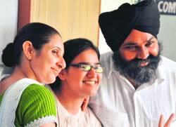 Ramandeep Kaur, topper in humanities, with her parents. Tribune photos