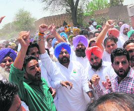Congress workers raise slogans against the Punjab Government at Mann village on Monday. 