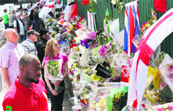 People read messages for Lee Rigby at the scene of his murder in Woolwich, London, on Monday. Reuters 