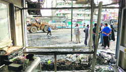 People gather at the scene of a blast in Baghdad's commercial Sadoun Street on Monday.  AFP