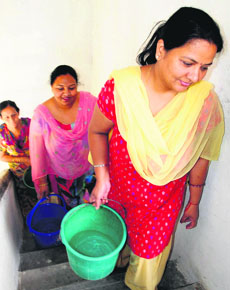 Women carry water in buckets from the ground floor in the Power Colony, Sector 52, Chandigarh. 
