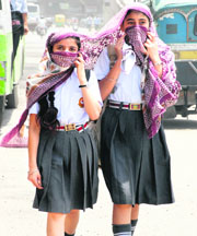 Schoolgirls cover their faces as heatwave again intensifies in Jalandhar on Tuesday.
