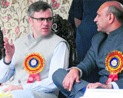 Chief Minister Omar Abdullah speaks to Union Minister of Human Resource Development MM Pallam Raju at a function in Ganderbal district on Tuesday.