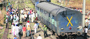 Railway employees lift the derailed coaches of a train with the help of machines near the Amritsar railway station on Wednesday. 