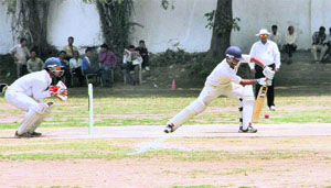A batsman plays a defensive shot in a match during the 31st All-India Uttarakhand Gold Cup Cricket Tournament at Rangers' College ground in Dehradun on Wednesday. 
