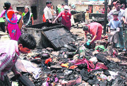 People look for their belongings in the debris of their hutments gutted at Vazirabad village in Gurgaon on Wednesday. Tribune photo: Sayeed Ahmed