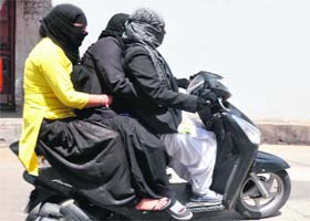 Taking the law for a ride: These women lawyers seem to care two hoots for traffic rules as they go for a triple ride on a scooter in Jammu on Wednesday