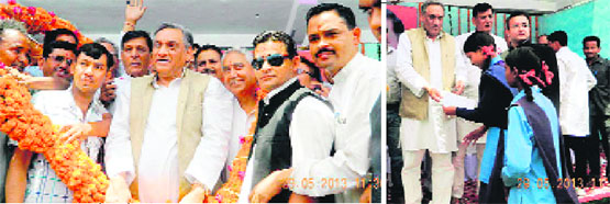 Chief Minister Vijay Bahuguna being greeted by by Congress workers at Dwarhat in Almora district (L) and Bahuguna distributes fixed deposit papers to girls at Dwarahat on Wednesday. 