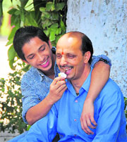 Aman, who scored 9.6 CGPA in the CBSE Class X exams, offers sweets to his father in Ludhiana on Thursday.